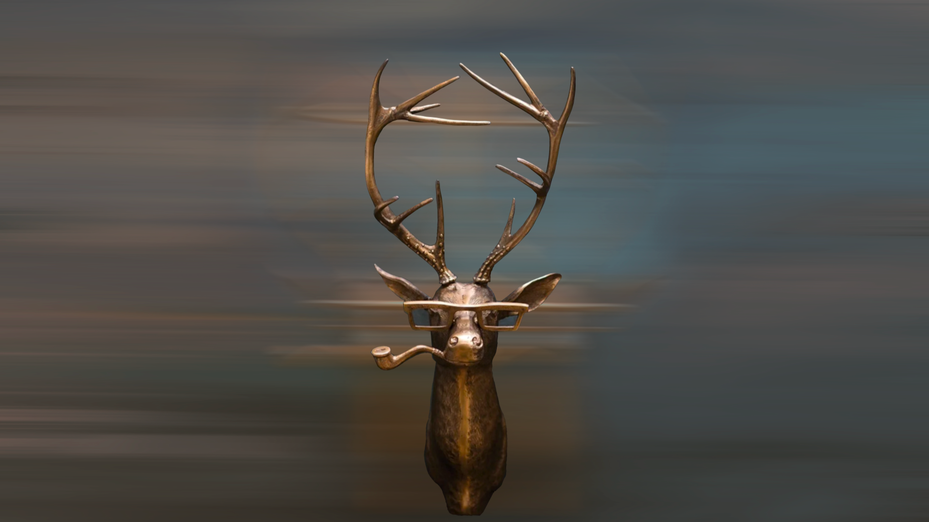 Bronze deer head sculpture with antlers against a blurred water background