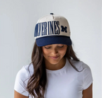 Person wearing a cap with 'Wolverines' text on a plain background